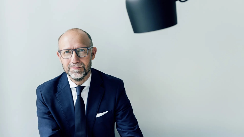 Mario Schuettauf ist Bereichsleiter Product Management Retail Clients. Portraitbild mit verschraenkten Armen.