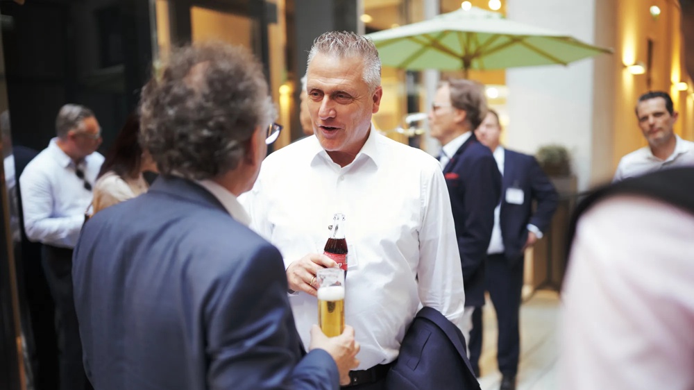 Networking scene at the Institutional-Gipfel Vienna 2026 – attendees in conversation at the get-together.