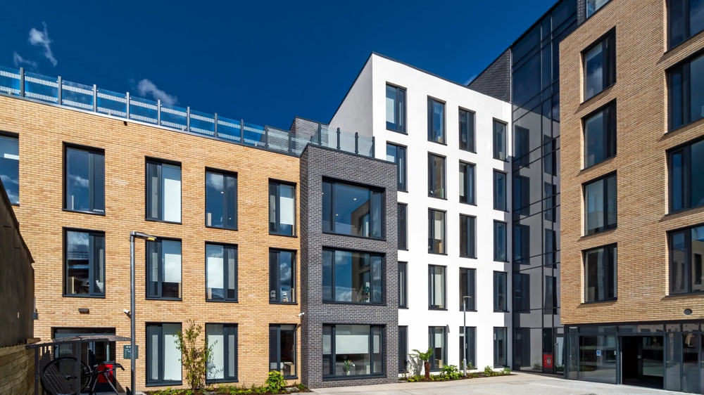 Courtyard view of a modern student residence in Stoneybutter, Dublin – facades in light brick, dark grey and white with large windows – an asset of the Commerz Real Institutional Smart Living Europe Fund.