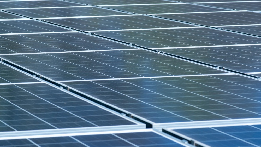 Detailansicht einer Solaranlage mit dicht angeordneten Photovoltaikmodulen in parallelen Reihen