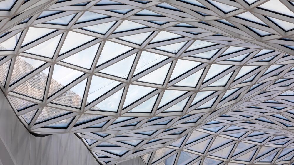 Moderne Glasdecke mit geometrischem, dreieckigem Muster und wellenförmigen Linien darunter.