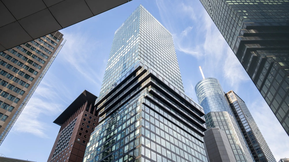 Mehrere moderne Wolkenkratzer ragen in den blauen Himmel, umgeben von Glasfassaden.