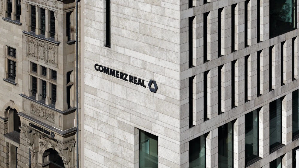 Modern and historic building facades with “Commerz Real” lettering.