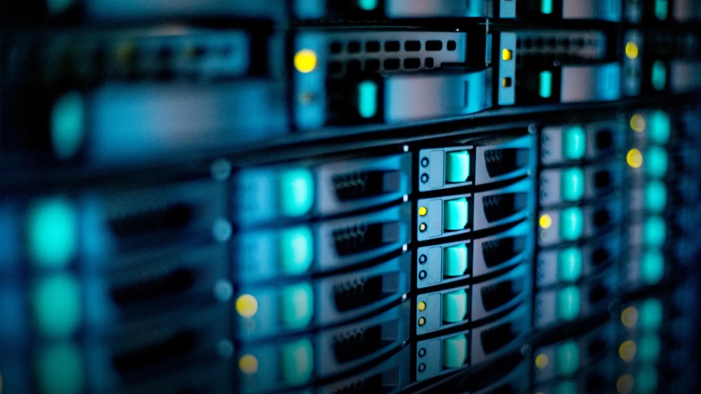 A stack of illuminated servers with blue and yellow lights in a data centre.