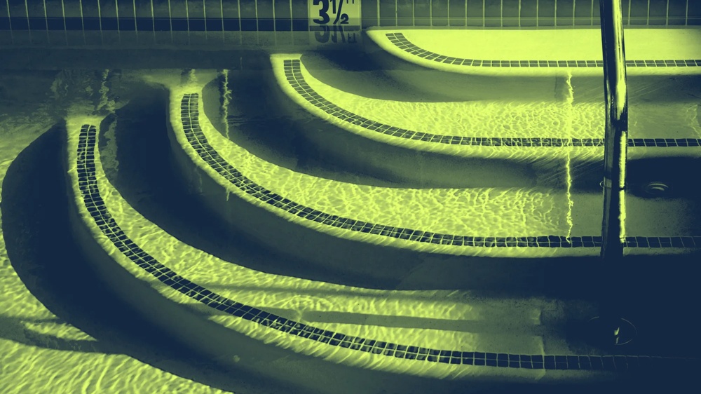 Treppenstufen eines Pools im Wasser, mit Fliesenrand und einem Handlauf bei 3,5 Fuß Tiefe.