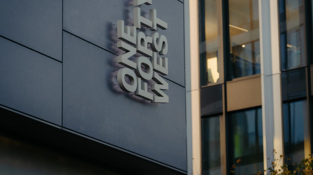 Detail einer Gebäudefassade mit Eingangsbereich und Beschriftung.