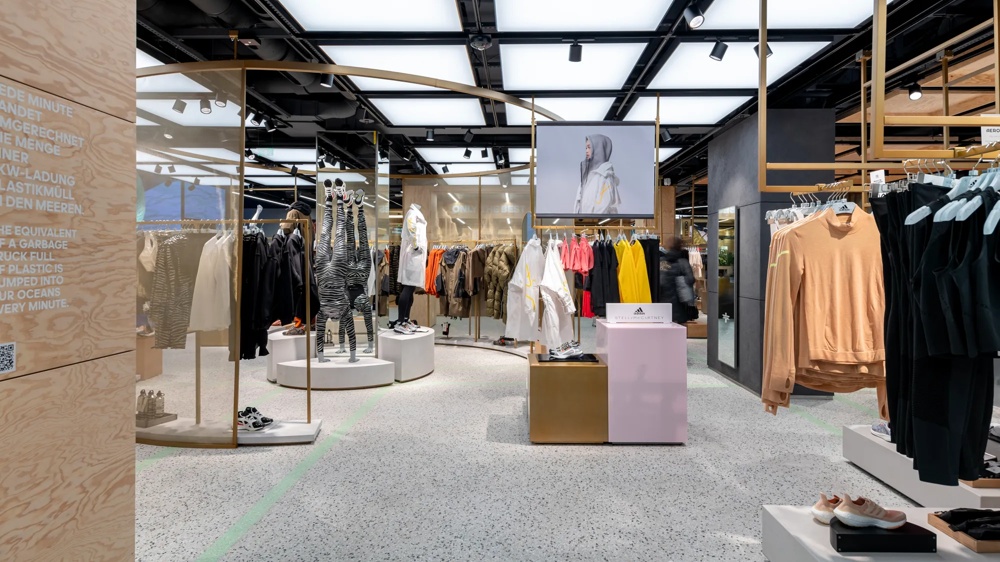 Ein moderner Bekleidungsladen mit Sportkleidung, Schaufensterpuppen und heller Beleuchtung.