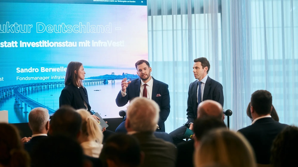 Drei Diskussionsteilnehmende auf der Bühne während einer Podiumsdiskussion beim Private Markets Forum 2026 in Frankfurt am Main.