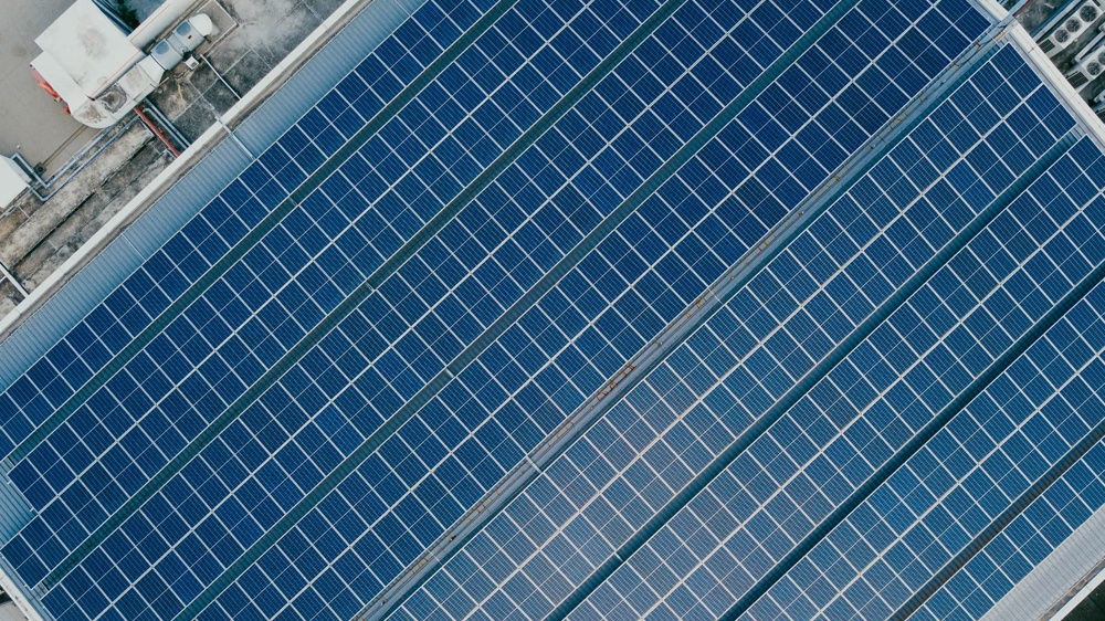 Solar modules on a roof in parallel rows from a bird’s-eye view.