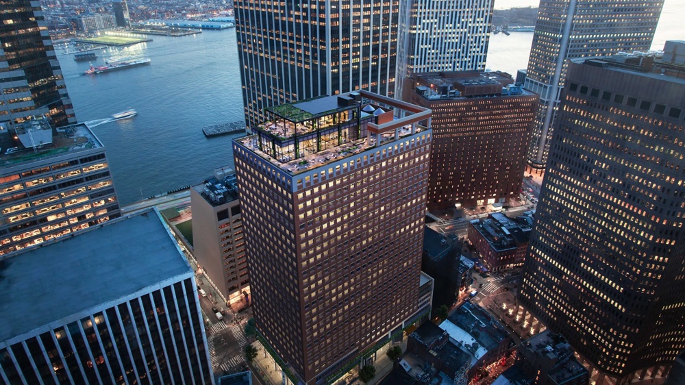 High-rise buildings at sunset overlooking a river and illuminated buildings, boats on the water.
