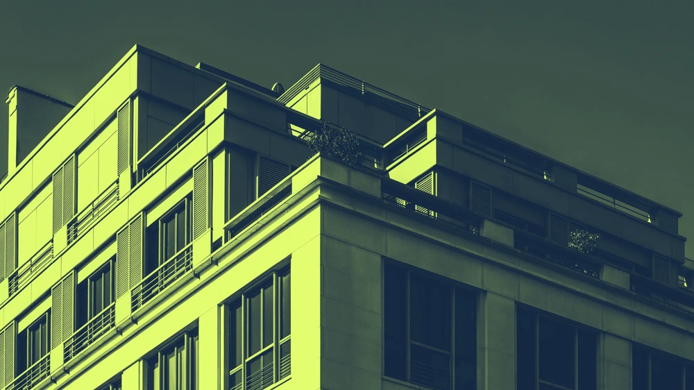 Moderne Gebäudefassade mit großen Fenstern und Balkonen, in grüner Tönung.