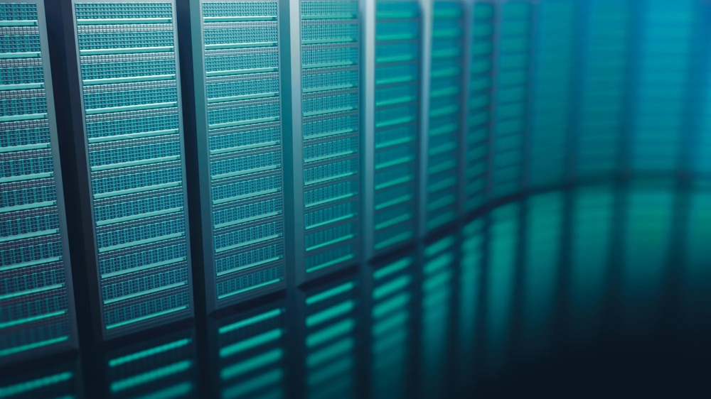 A row of blue server racks in a data centre, illuminated with cool light.