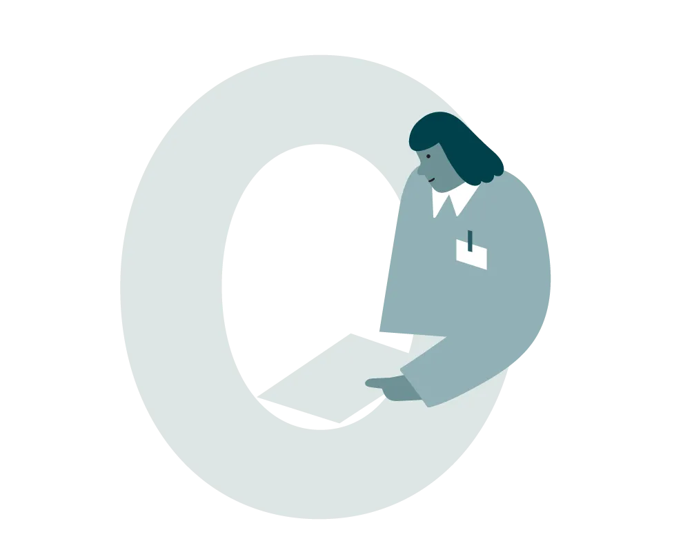 A person in a grey suit points to a large, light “Q”.
