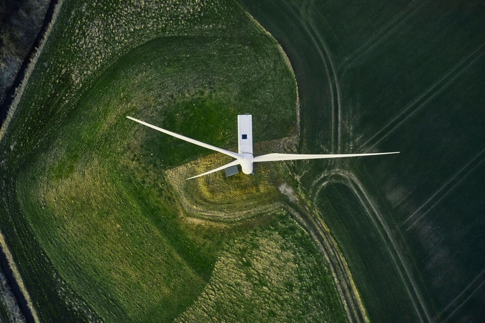 Windmill from above on green field with curved paths.