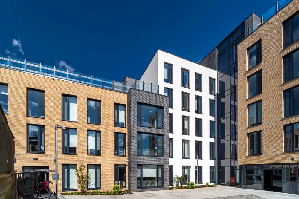 Innenhofansicht eines modernen Studentenwohnheims in Stoneybutter, Dublin – Fassaden in hellem Backstein, Dunkelgrau und Weiß mit großflächigen Fenstern – ein Objekt des Institutional Smart Living Europe Fund der Commerz Real.