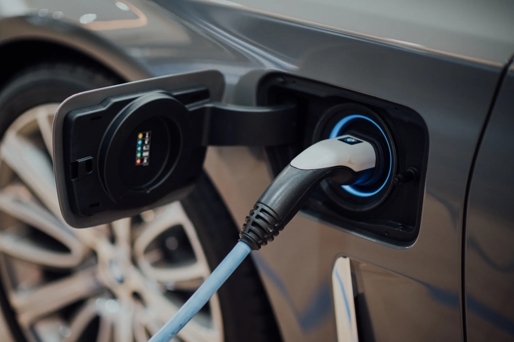 Ein Elektroauto wird über ein Ladekabel an einer Ladestation aufgeladen.