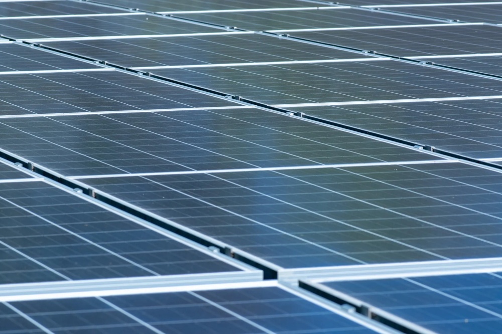 Detailansicht einer Solaranlage mit dicht angeordneten Photovoltaikmodulen in parallelen Reihen