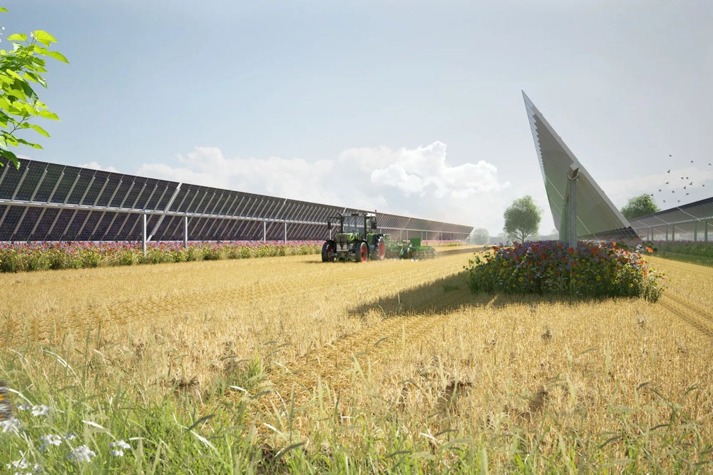 Ein Traktor fährt durch ein Feld neben Solarpaneelen und bunten Blumen unter blauem Himmel.