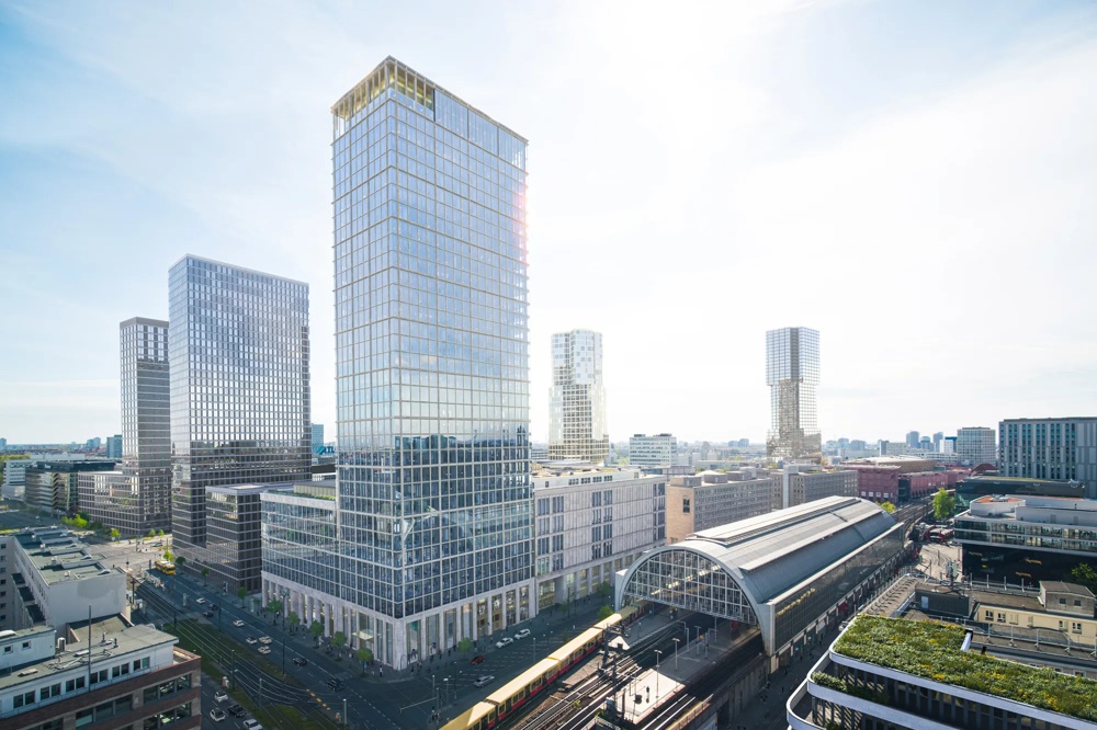Moderne Stadtansicht mit Hochhäusern, einem großen Bahnhof und einer vorbeifahrenden gelben S-Bahn unter klarem Himmel.