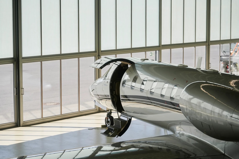 Ein Privatjet steht in einem Hangar, mit geöffneter Tür und heruntergelassener Treppe.