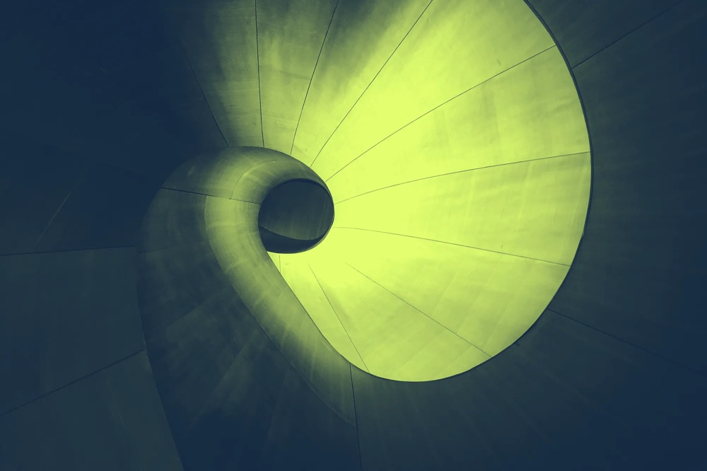 Abstrakte, spiralförmige Struktur in Grün und Blau, die sich nach innen windet.