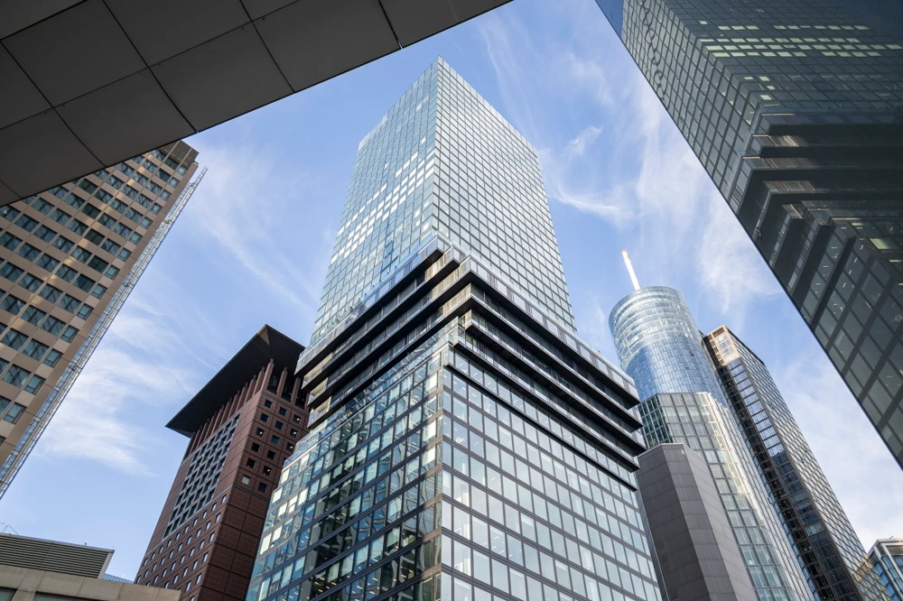 Mehrere moderne Wolkenkratzer ragen in den blauen Himmel, umgeben von Glasfassaden.