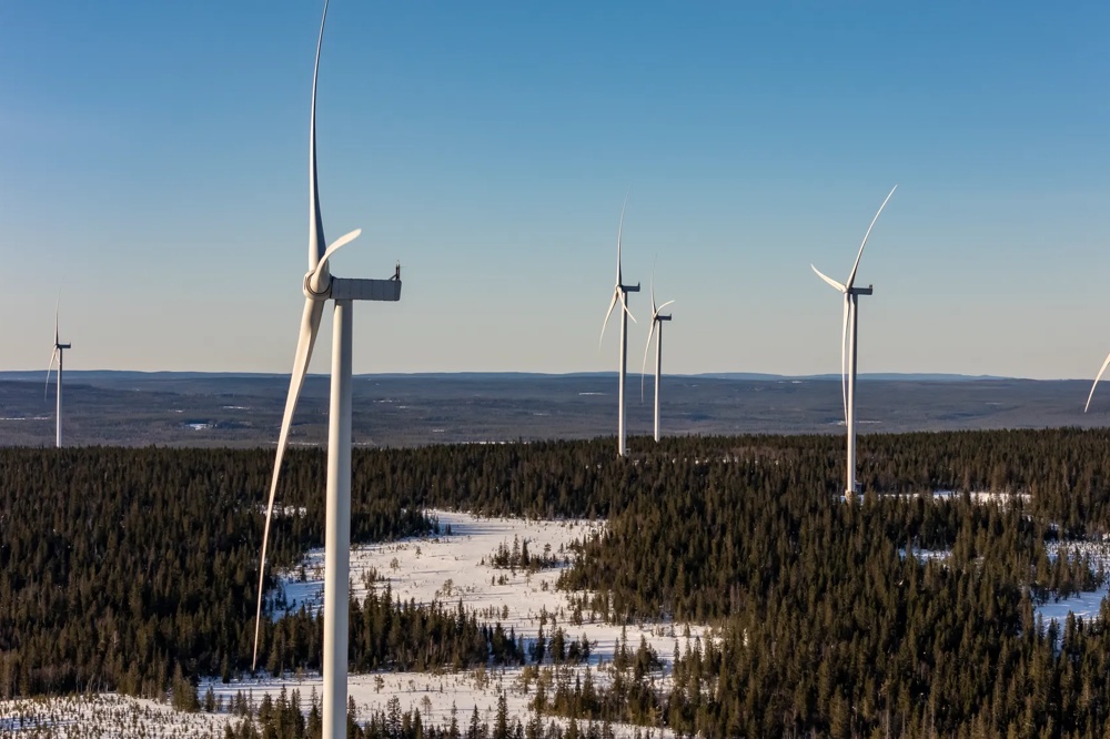 A wind farm standing in a winter landscape under a blue sky