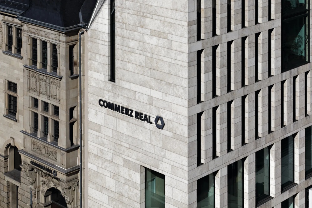 Moderne und historische Gebäudefassaden mit "Commerz Real" Schriftzug.