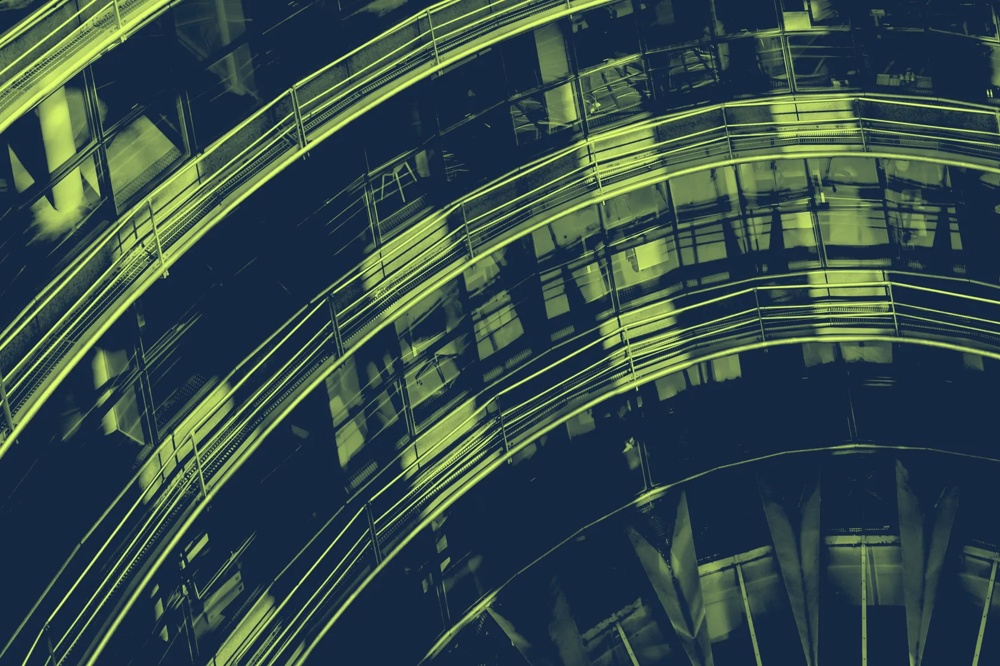 Geschwungene, beleuchtete Metallstrukturen in einem futuristischen Gebäude, mit reflektierenden Glasflächen.