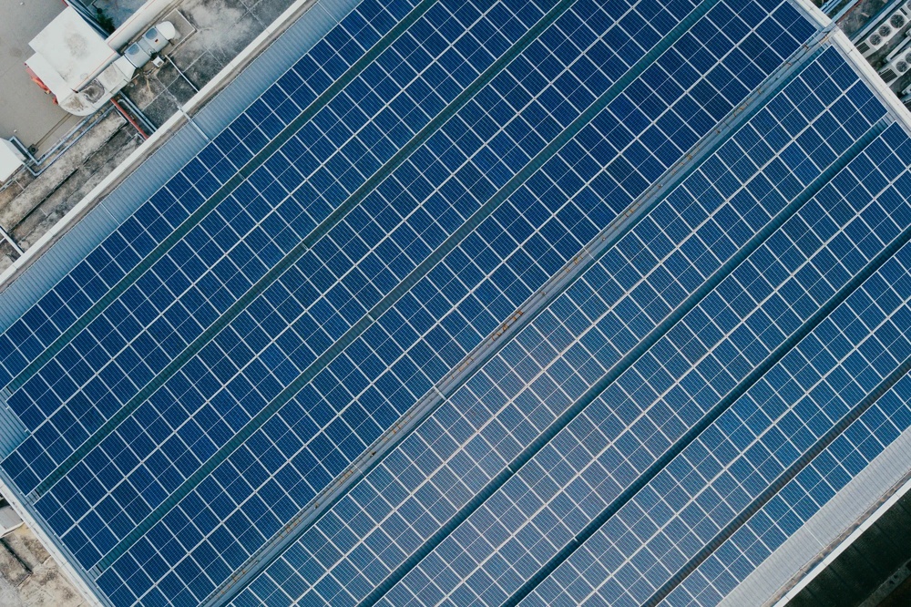 Solarmodule auf einem Dach in parallelen Reihen aus der Vogelperspektive.