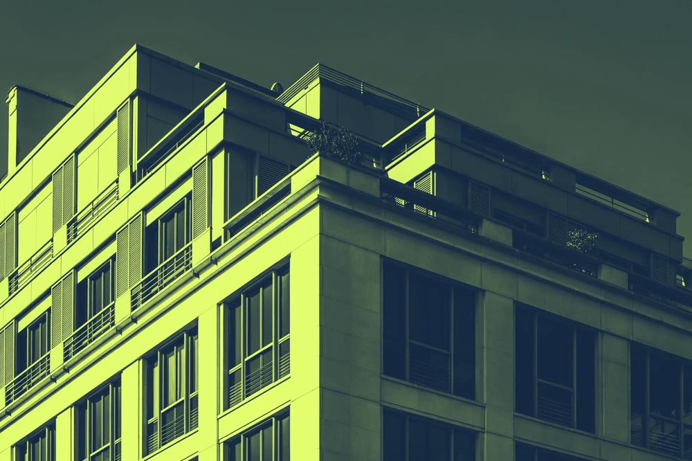 Moderne Gebäudefassade mit großen Fenstern und Balkonen, in grüner Tönung.