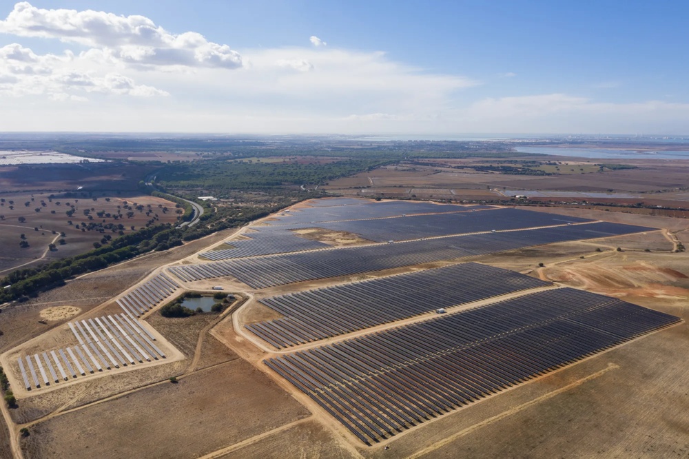 Luftaufnahme eines großflächigen Solarparks mit Photovoltaikmodulen in trockener Landschaft