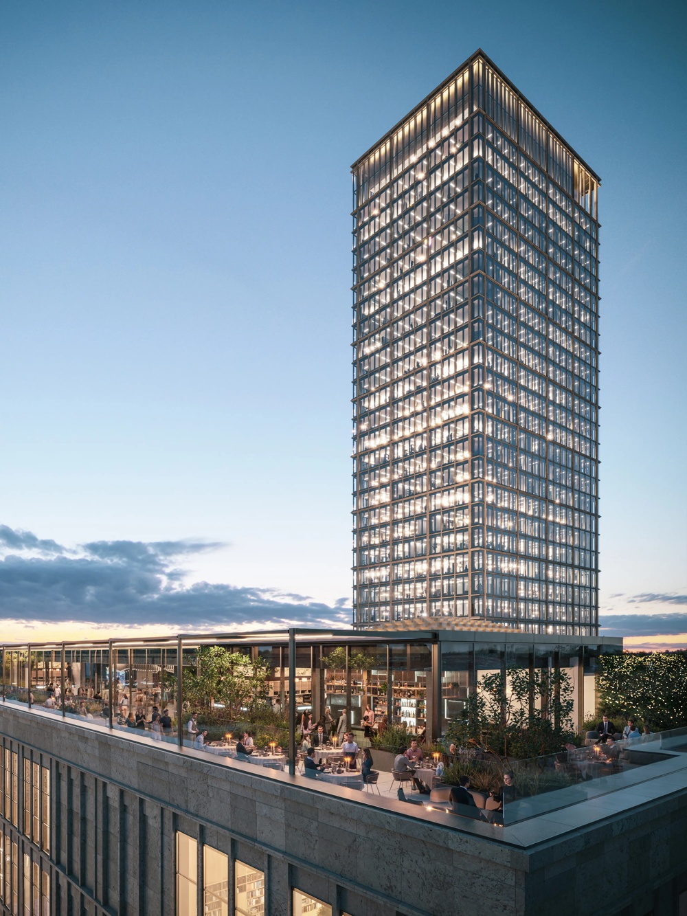 A television tower next to an illuminated high-rise at sunset, with a terrace in the foreground.