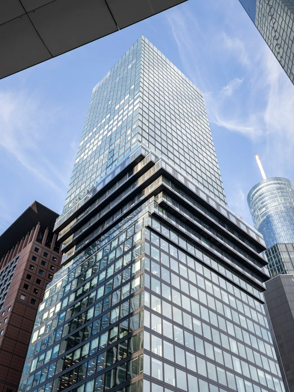 Mehrere moderne Wolkenkratzer ragen in den blauen Himmel, umgeben von Glasfassaden.