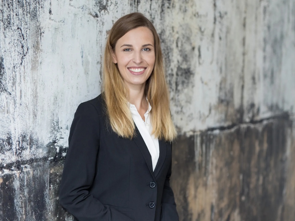 Zu sehen ist Laura Haidl-Schöpf im Portrait stehend vor einer rauen Wand