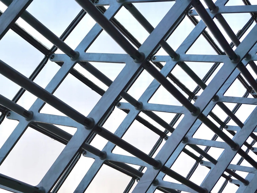 Detailaufnahme eines Bauwerks aus Sichtbeton vor blauem Himmel