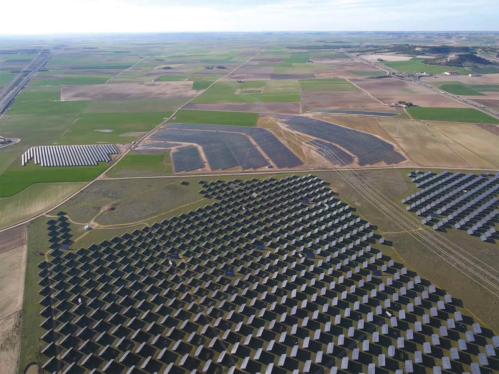 Luftaufnahme von Solarfeldern und grünen Feldern in einer ländlichen Landschaft.