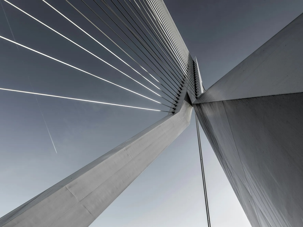 Moderne Schrägseilbrücke mit klaren Linien vor blauem Himmel, diagonale Perspektive.