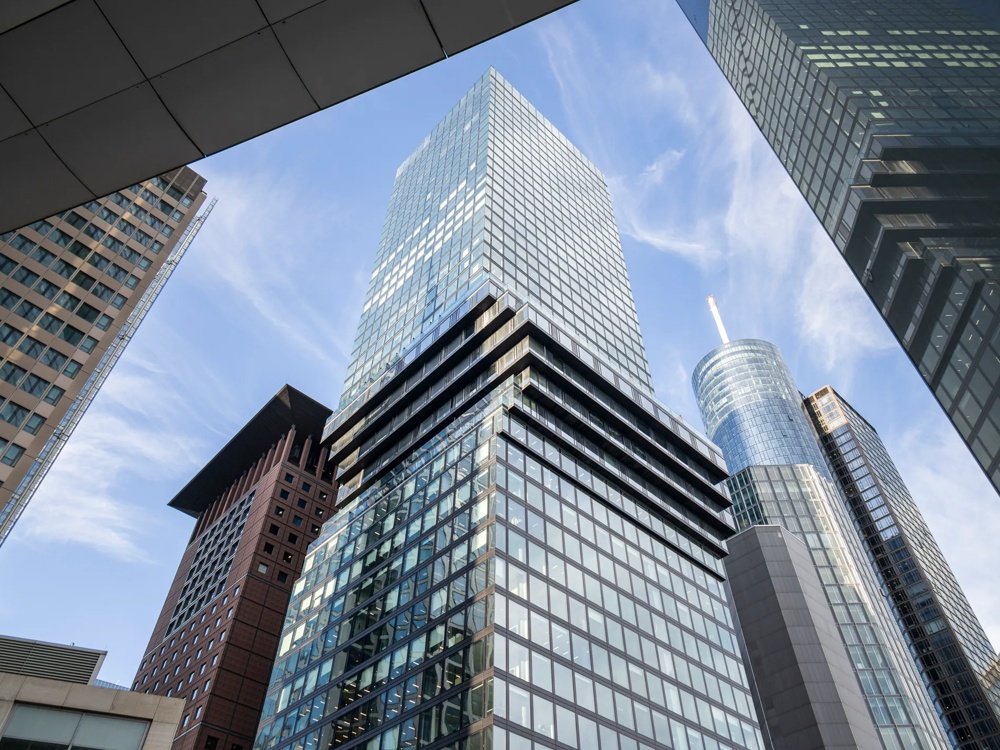 Mehrere moderne Wolkenkratzer ragen in den blauen Himmel, umgeben von Glasfassaden.