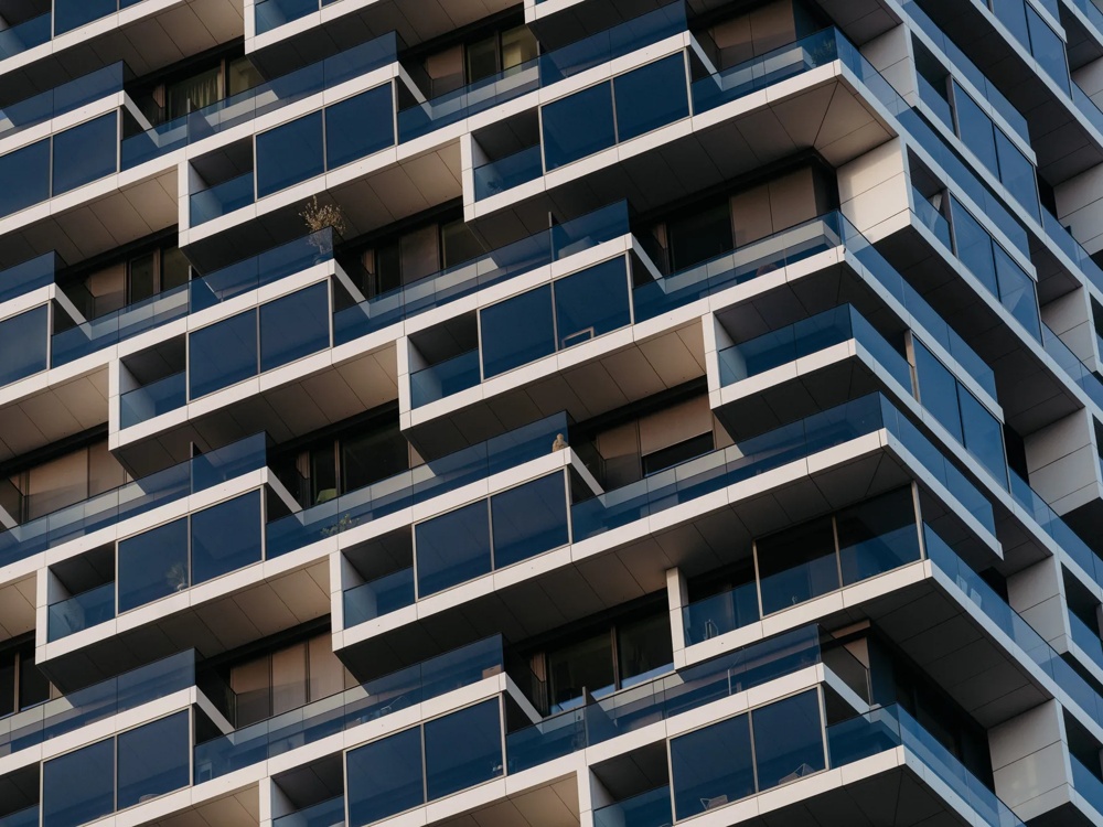 Detail einer Hochhausfassade mit Balkonen und klarer Linienstruktur.
