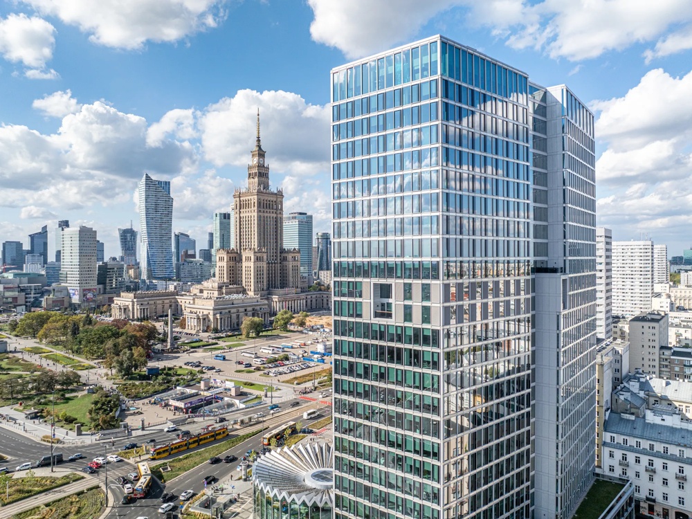 Moderne Hochhäuser und historisches Gebäude unter blauem Himmel mit Wolken.