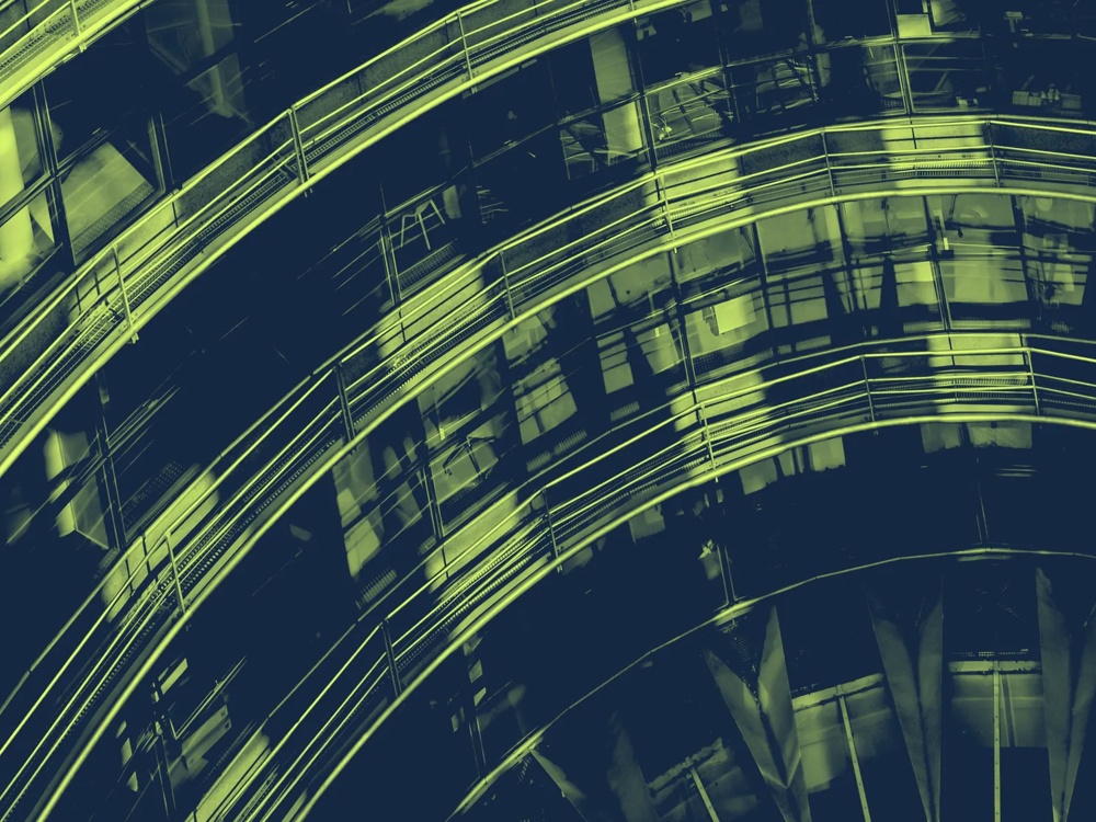 Geschwungene, beleuchtete Metallstrukturen in einem futuristischen Gebäude, mit reflektierenden Glasflächen.