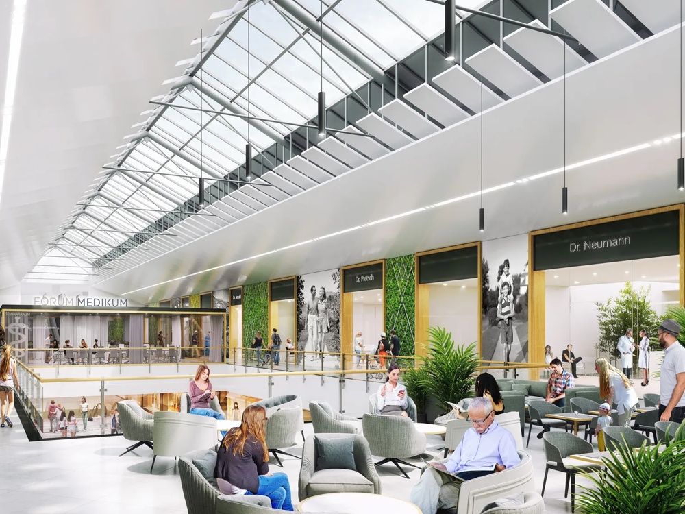 Menschen gehen durch ein modernes Einkaufszentrum mit Glasdach und grünen Wänden.