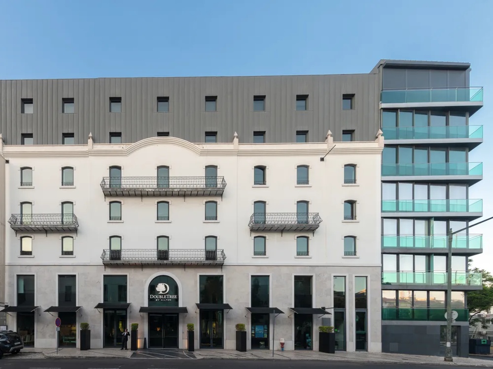gezeigt wird eines aussenaufnahme der commerz real institutionals immobilie double tree by hilton in lissabon. die aufnahme stellt das hotel von aussen dar.