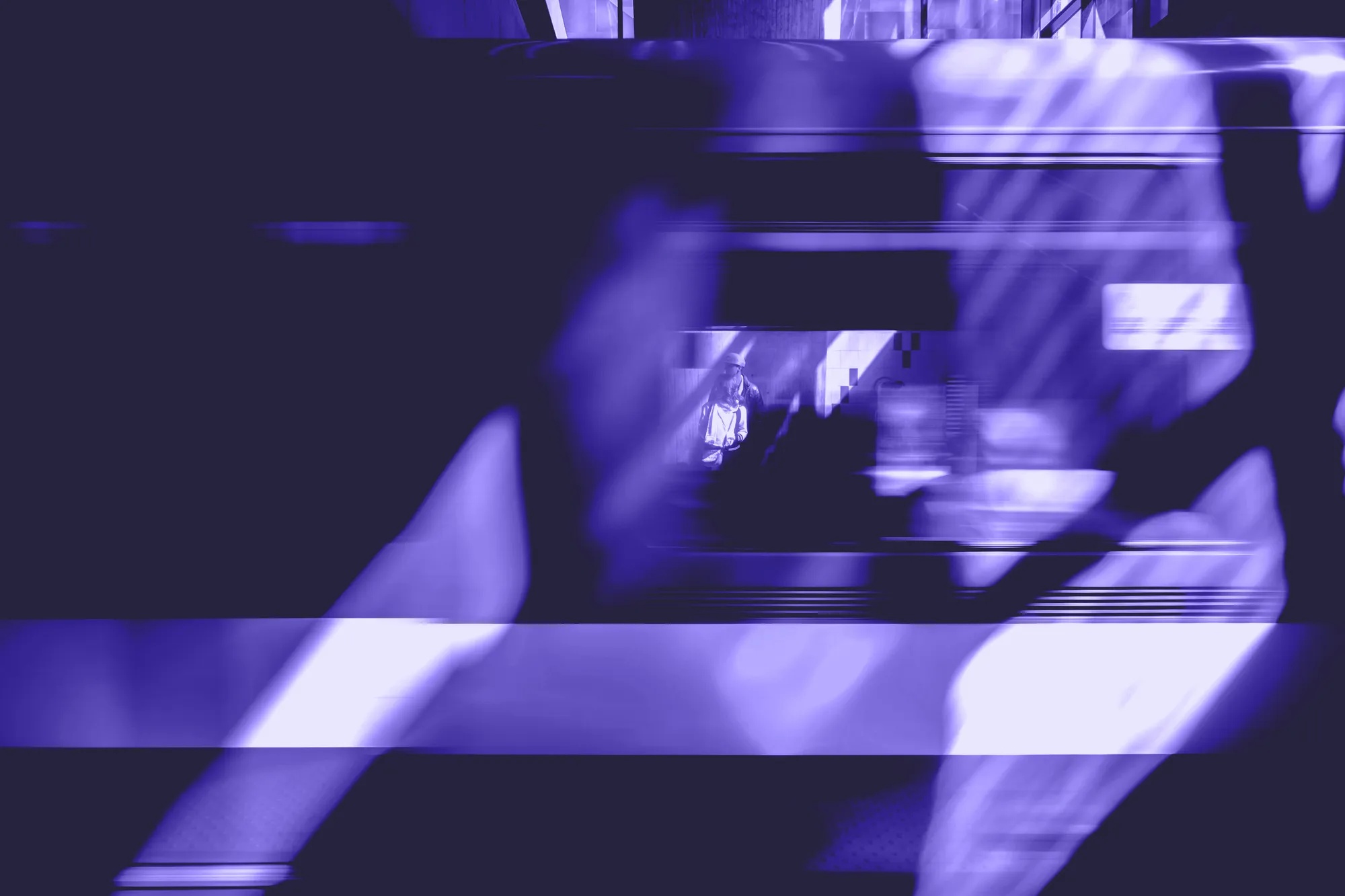 Verschwommene Silhouette vor einem Fenster, durch das eine Person in einem Zug sichtbar ist.