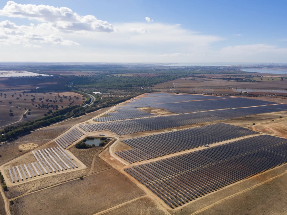 Luftaufnahme eines großflächigen Solarparks mit Photovoltaikmodulen in trockener Landschaft