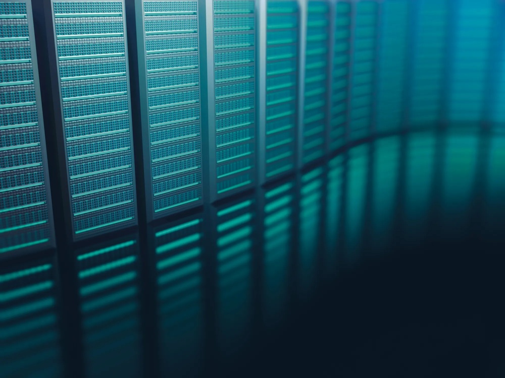 Reihe von blauen Server-Racks in einem Rechenzentrum, beleuchtet mit kühlem Licht.