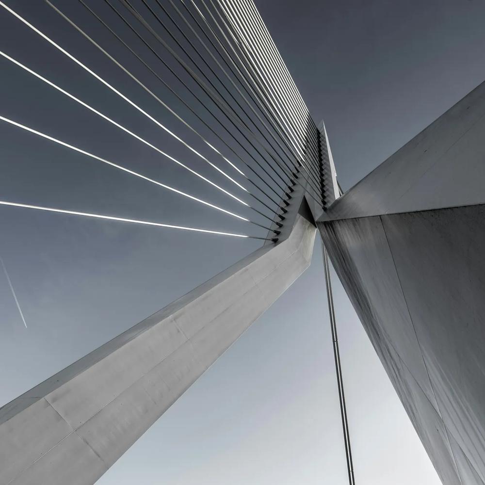 Moderne Schrägseilbrücke mit klaren Linien vor blauem Himmel, diagonale Perspektive.