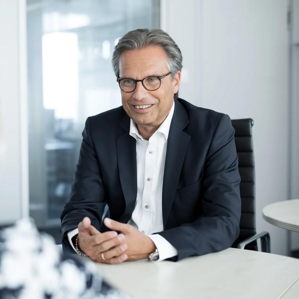 Christoph Halstrick, former Global Head of Equipment Leasing Sales, is talking to a woman while gesticulating